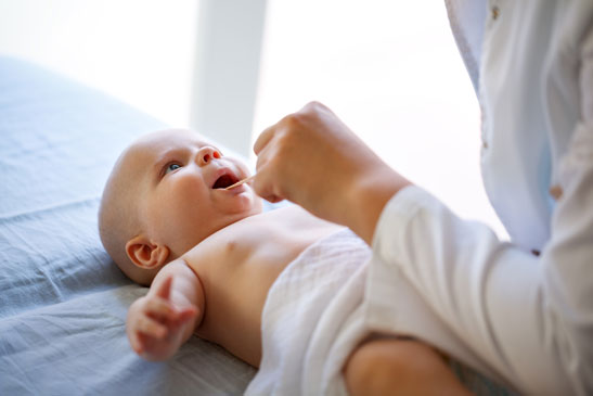Arzt untersucht ein Baby mit Mundsoor